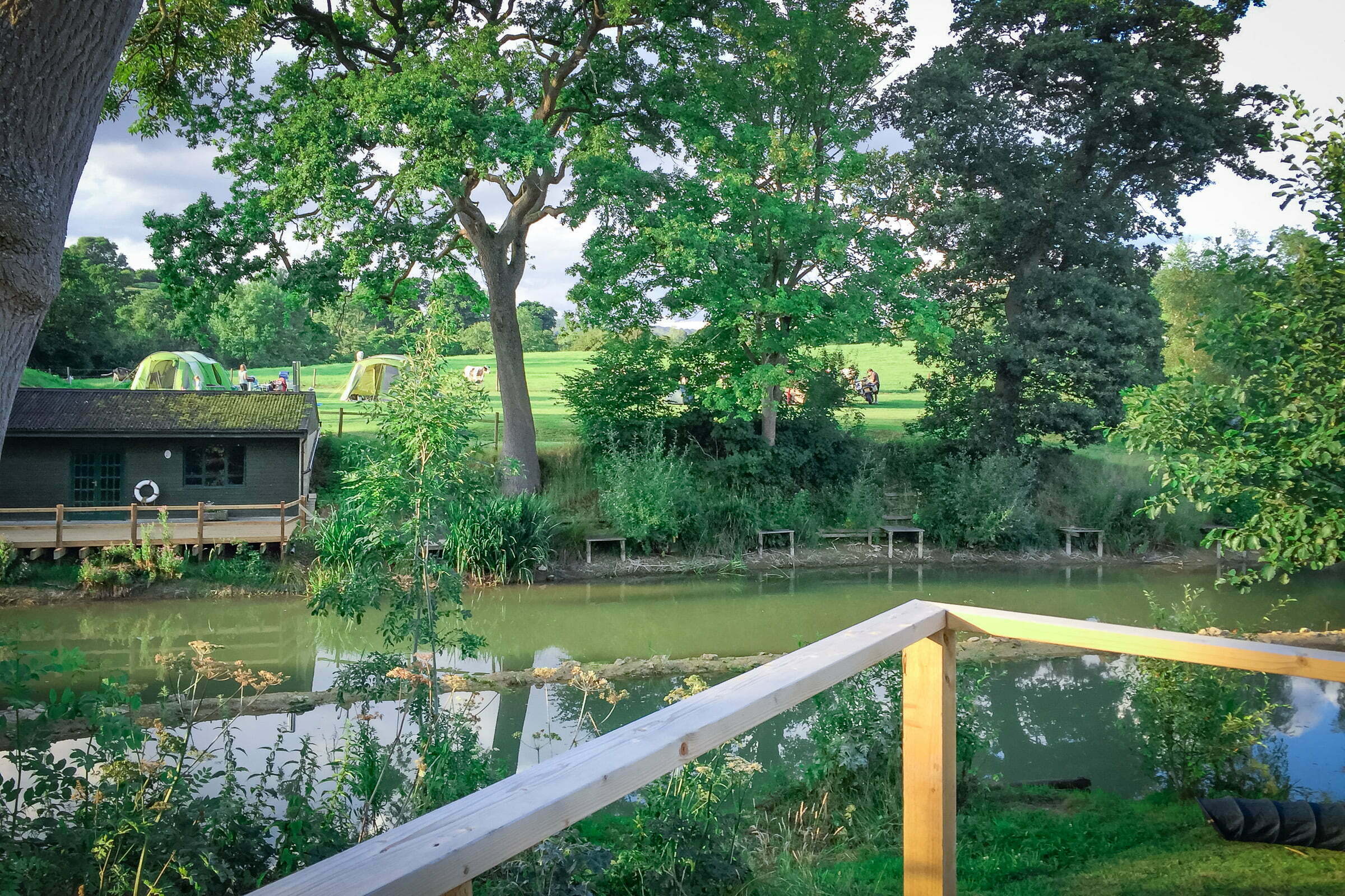 Painswick Glamping – Mill Pool Pod view of lake and tent sites